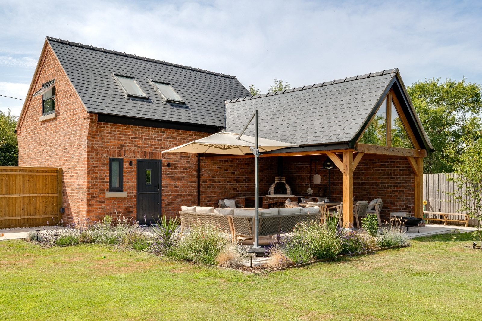 Brick outbuilding with slate roof and oakframe covered pavilion