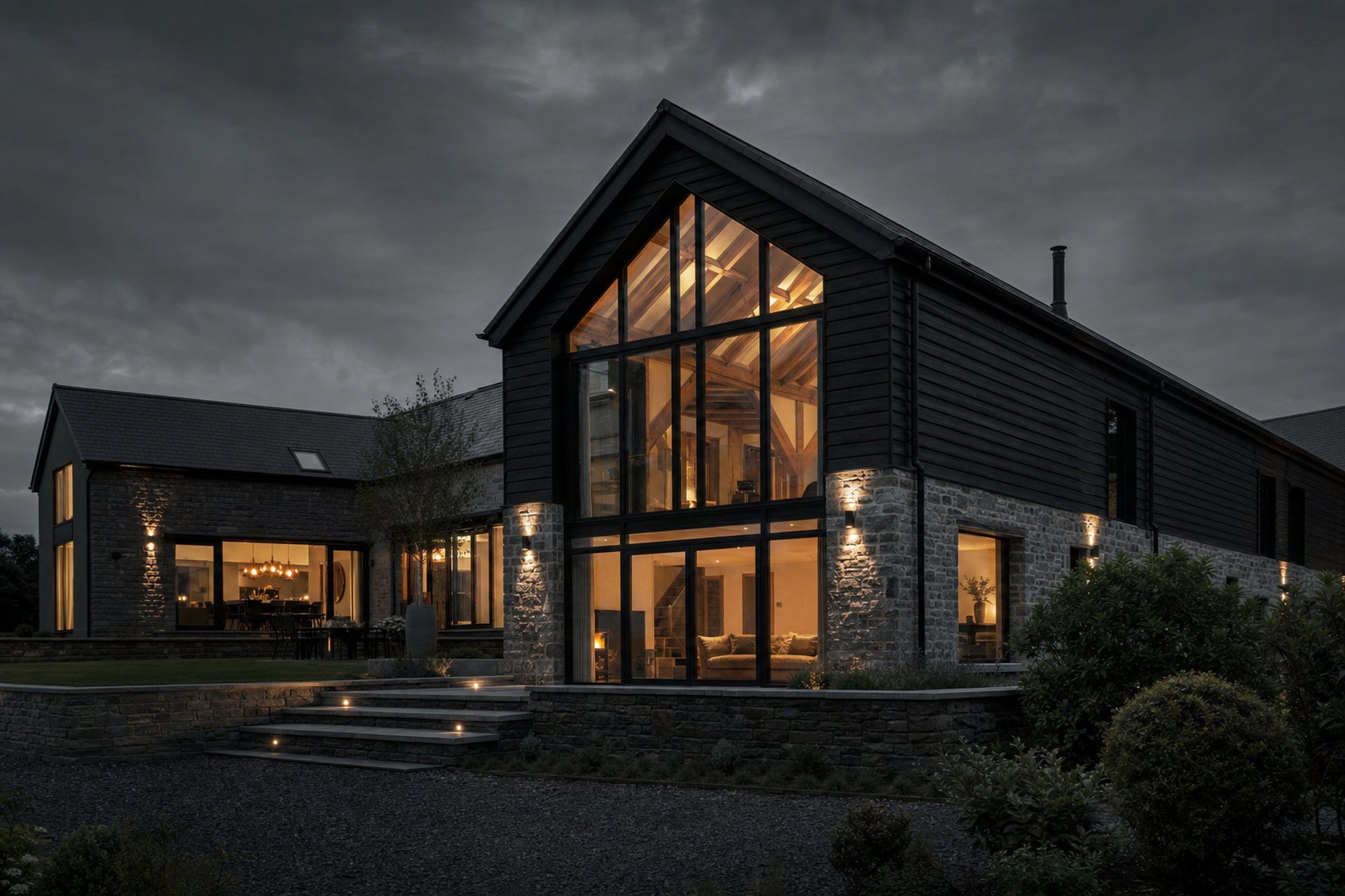 A beautifully renovated barn conversion at dusk with warm interior light