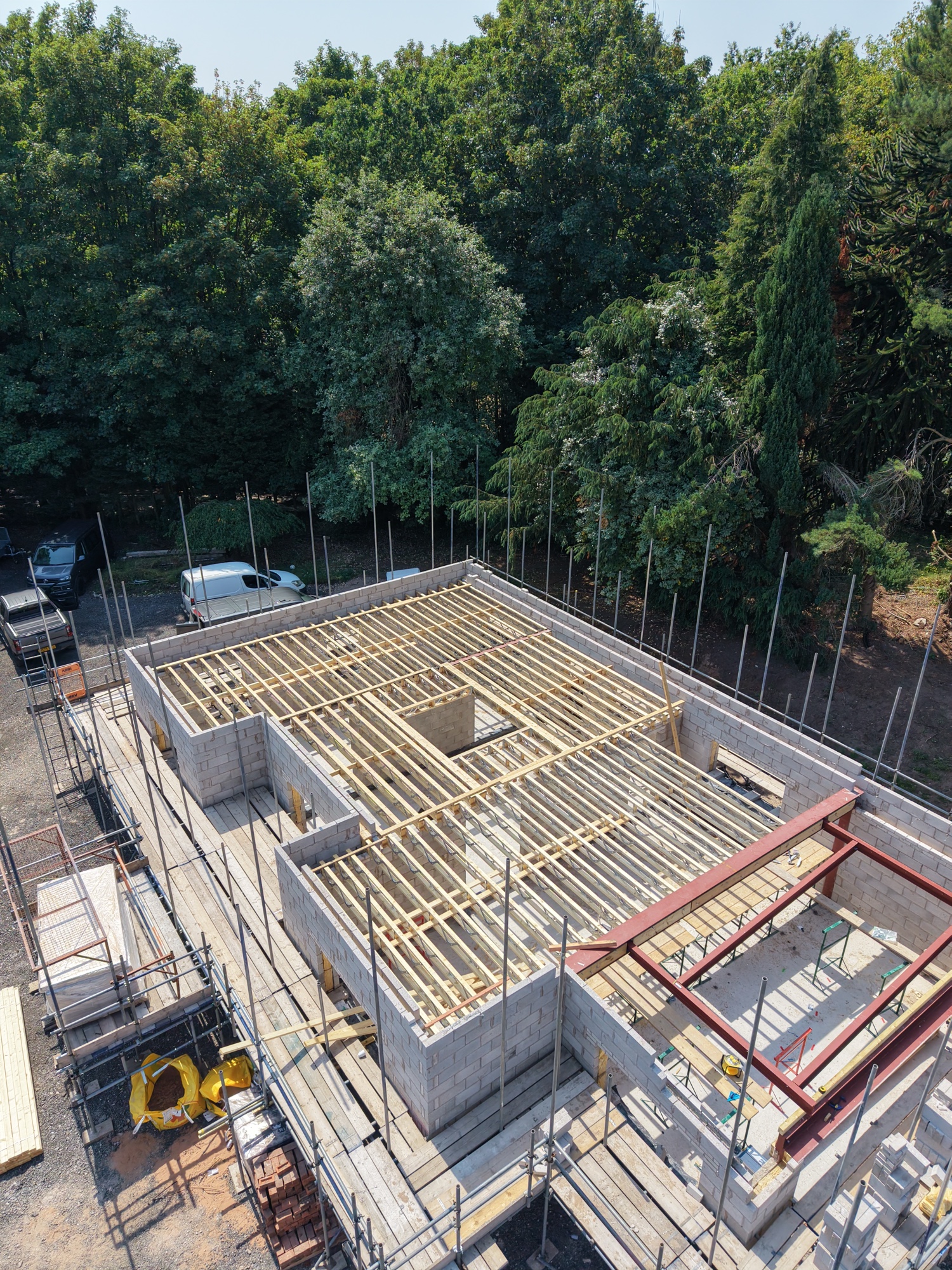 A live Built Clear build in rural Cheshire — first-floor joists laid, structural steel dressed in, scaffold ready for the next lift.